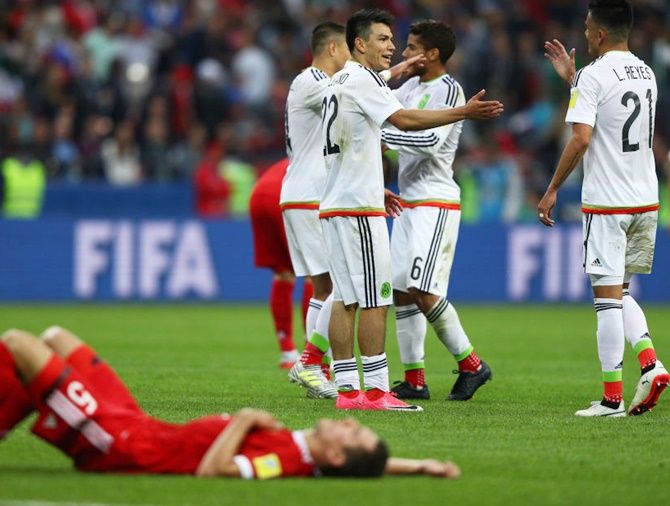 Mexico players celebrate their 2-1 victory while Viktor Vasin of Russia shows dejection