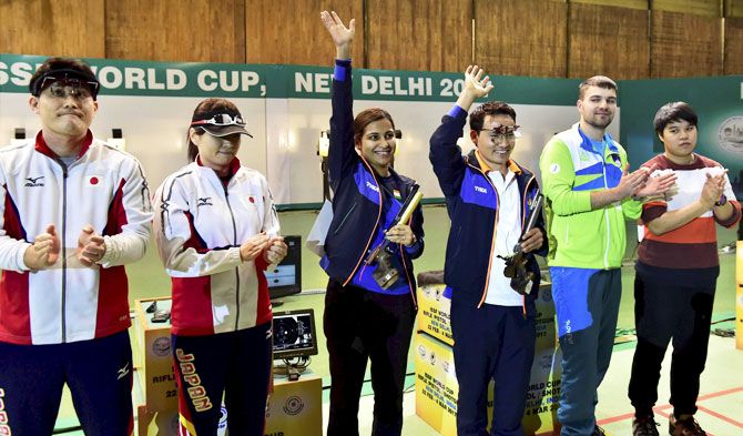 India's Heena Sidhu and Jitu Rai (centre) celebrate after winning mixed team 10m Air Pistol event of the ISSF World Cup in New Delhi on Monday