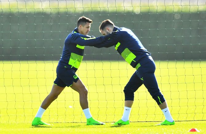 Strikers Alexis Sanchez and Lucas Perez warm up during the Arsenal training session at London Colney in St Albans, England, on Monday