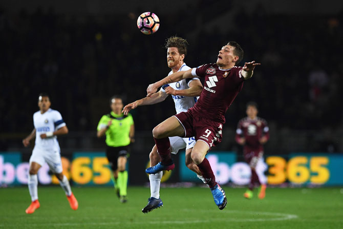 FC Torino's Andrea Belotti (right) clashes with Inter's Cristian Ansaldi as they vie for possession during the Serie A match at Stadio Olimpico di Torino in Turin on Sunday