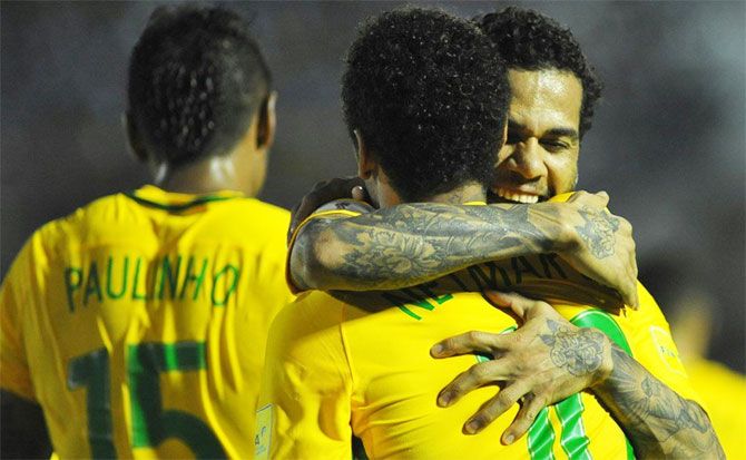 Brazil's Dani Alves and Neymar celebrate after their 4-1 victory over Uruguay on Thursday
