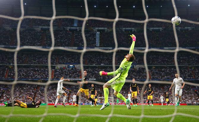 Real Madrid's Cristiano Ronaldo (2nd from left) scores their second goal past goalkeeper Atletico Madrid 'keeper Jan Oblak