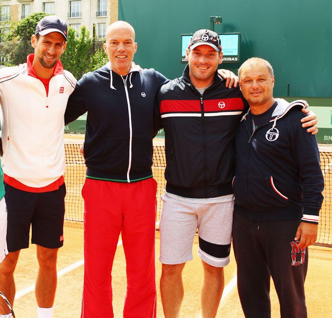 Novak Djokovic (Left) poses with physical trainer Gebhard Phil-Gritsch, physiotherapist Milan Amanovic and coach Marian Vajda during a practice session at Roland Garros on June 5, 2012
