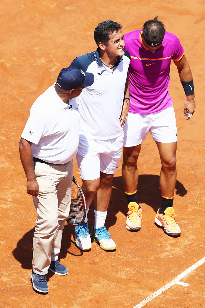 Spain's Nicolas Almagro (centre) is helped off court by Rafael Nadal (right) and umpire Carlos Bernardes (left) after retiring at 0-3 in the opening set on Day Four of The Internazionali BNL d'Italia 2017 at the Foro Italico in Rome, Italy, on Wednesday