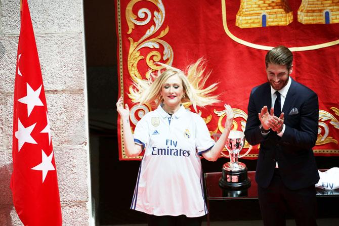 Real Madrid's Sergio Ramos presents Cristina Cifuentes, President of the Community of the Madrid, a personalised Real Madrid jersey during a ceremony at the headquarters of Madrid's regional government on Monday