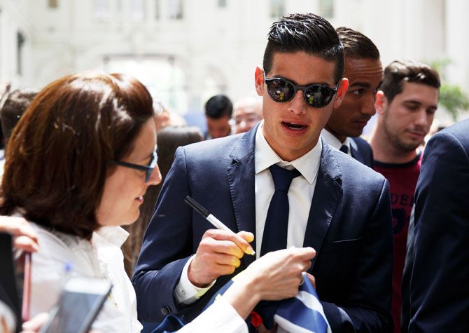 Real Madrid's James Rodriguez signs an autograph during a ceremony at the Town Hall in Madrid on Monday
