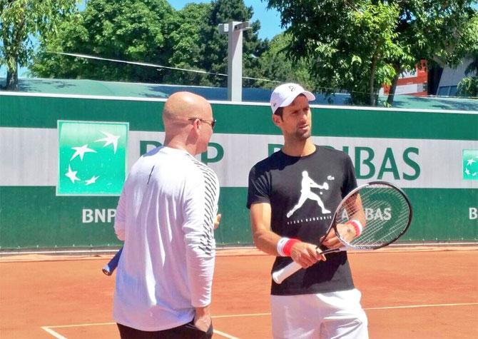 American tennis legend Andre Agassi shares his insights with new ward Novak Djokovic during a training session on Thursday