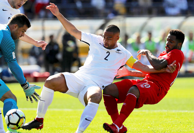 New Zealand's goalkeeper Stefan Marinovic stops the ball as teammate Winston Reid pushes away Peru's Jefferson Farfan during their 2018 World Cup Qualifying Playoffs at Westpac Stadium, Wellington, New Zealand, on Saturday