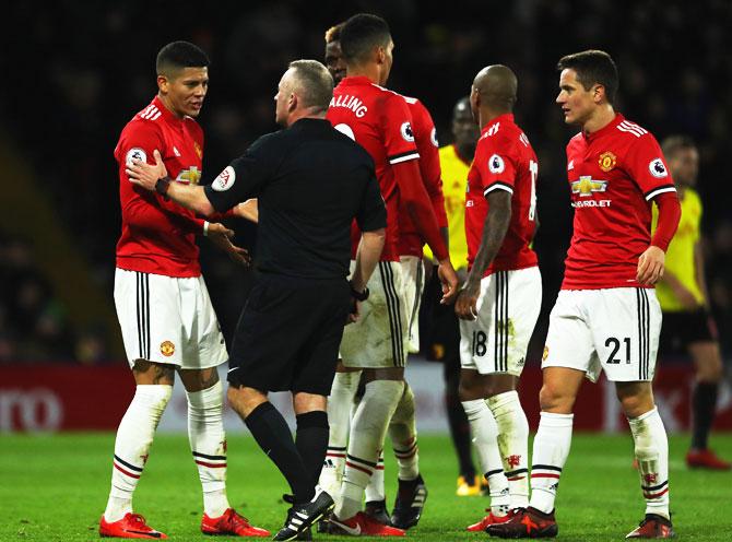 Manchester United's Marcos Rojo (left) in discussion with referee Jonathan Moss during their English Premier League match at Vicarage Road in Watford on Tuesday