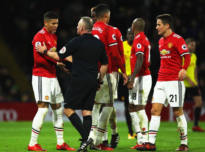 Manchester United's Marcos Rojo (left) in discussion with referee Jonathan Moss during their English Premier League match at Vicarage Road in Watford on Tuesday