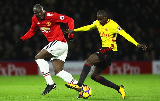 Watford's Abdoulaye Doucoure holds off Manchester United's Romelu Lukaku as they battle for the ball during their English Premier League match at Vicarage Road in Watford on Tuesday