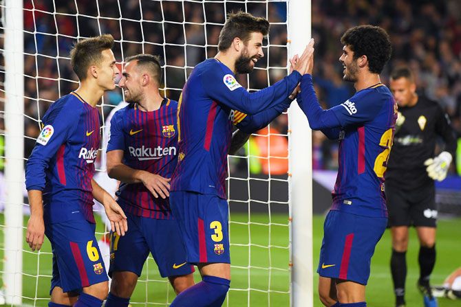 FC Barcelon's Gerard Pique (centre) celebrates with his teammates after scoring his team's second goal against Real Murcia during the Copa del Rey round of 32 second leg match at Camp Nou in Barcelona on Wednesday