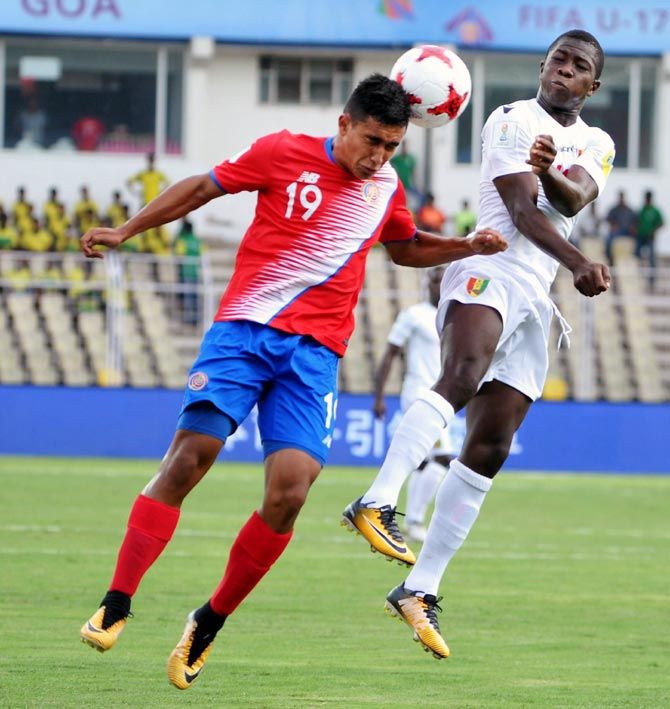 Players of  Costa Rica and Guinea vie for the ball 