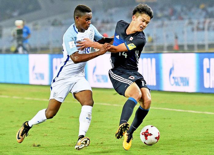 England defender defender Steven Sessegnon (18) and Japan's Soichiro Kozuki (14) vie for the ball during FIFA U-17 World cup pre-quarter final in Kolkata on Tuesday