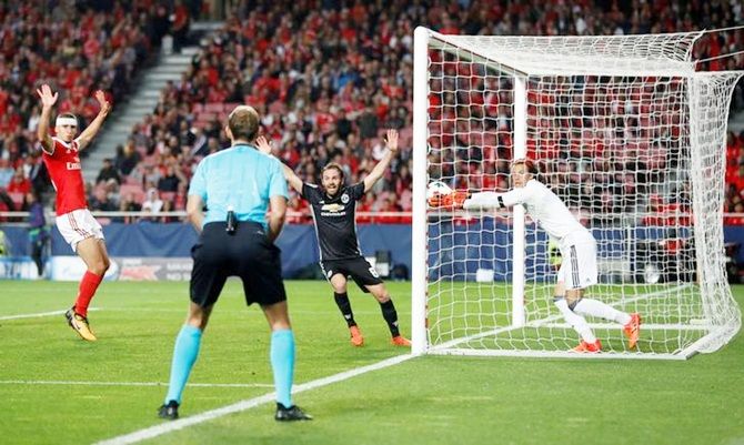 Benfica goalkeeper Mile Svilar carries the ball over the line 