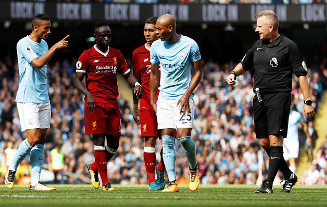Liverpool's Sadio Mane (2nd from left) walks off the pitch after receiving the red card from referee Jon Moss for crashing into and injuring Manchester City keeper Ederson while going for a high ball during  their English Premier League match in Manchester on Saturday