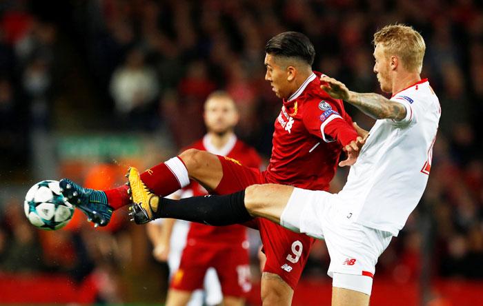 Liverpool's Roberto Firmino and Sevilla’s Simon Kjaer vie for possession 