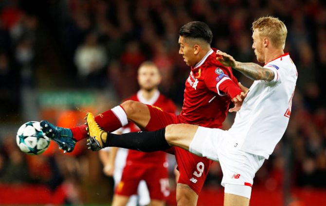 Liverpool's Roberto Firmino and Sevilla’s Simon Kjaer vie for possession 