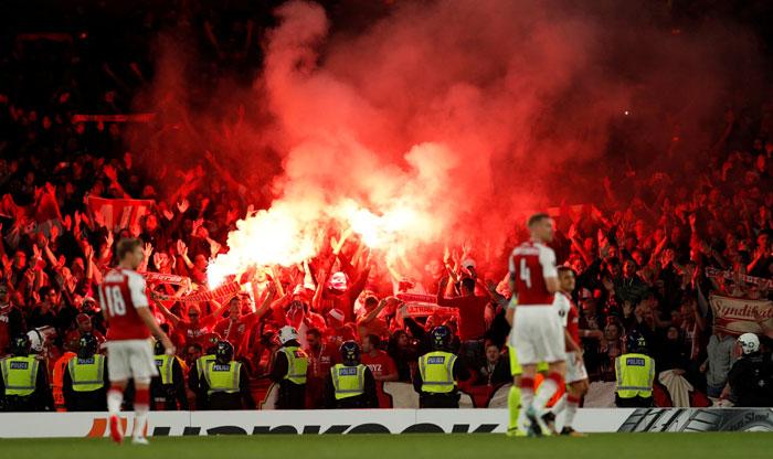 FC Koln fans celebrate their first goal by letting off flares during the Europa League match against Arsenal at Emirates Stadium in London on Thursday