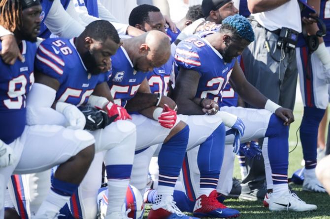 Buffalo Bills players kneel during the American National anthem.  When black football players knelt during the national anthem to protest against police brutality in 2016, President Donald Trump denounced them with an expletive and the NFL effectively took his side, telling players to stand or stay off the field for the song.