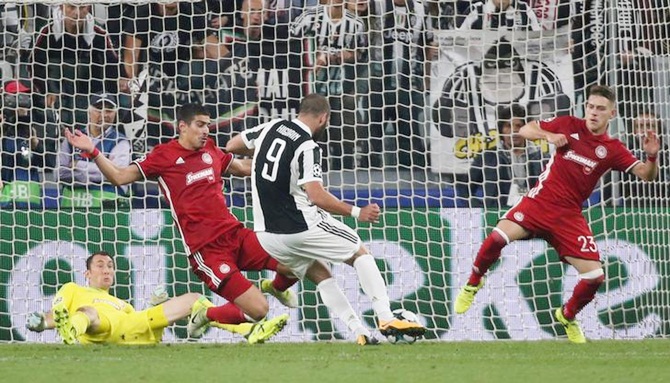 Gonzalo Higuain scores Juventus's first goal against Olympiakos.