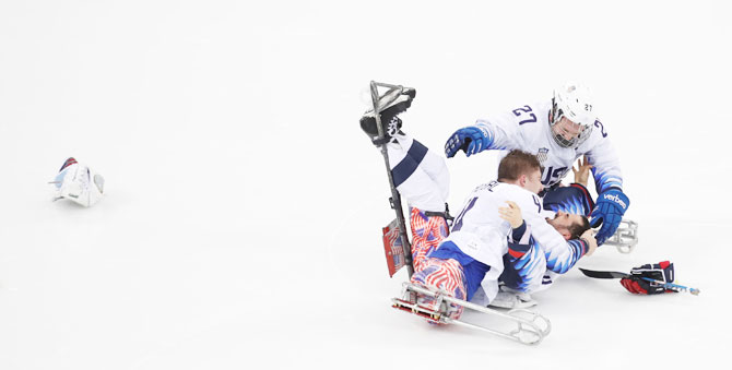 USA's Brody Roybal and his teammates Josh Pauls and Joshua Misiewicz celebrate winning the Ice Hockey gold medal against Canada aat the Gangneung Hockey Centre, in Gangneung, South Korea on March 18