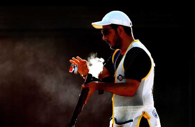 Cyprus' Georgios Achilleos clears the barrel of his gun in the final of the Men's Skeet event at Belmont Shooting Centre in Brisbane on Monday