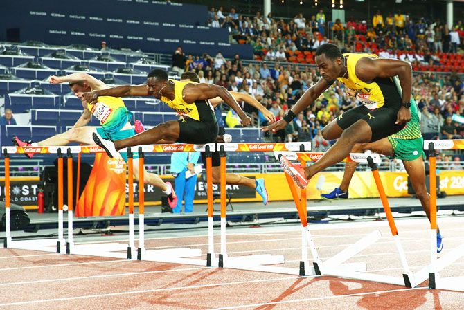Australia's Nicholas Hough, Jamaica's Ronald Levy and Jamaica's Hansle Parchment clear the final hurdle in the Men's 110 hurdles final at Carrara Stadium on Tuesday