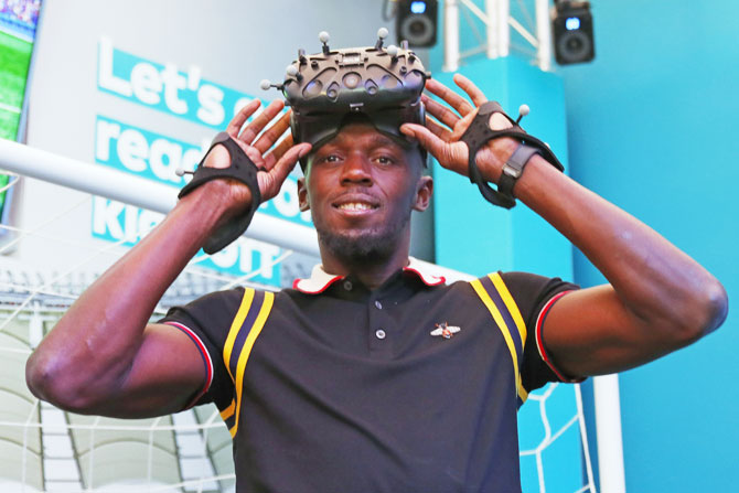 Former Jamaican sprinter Usain Bolt wears a VR headset during a press conference at Gold Coast on Thursday