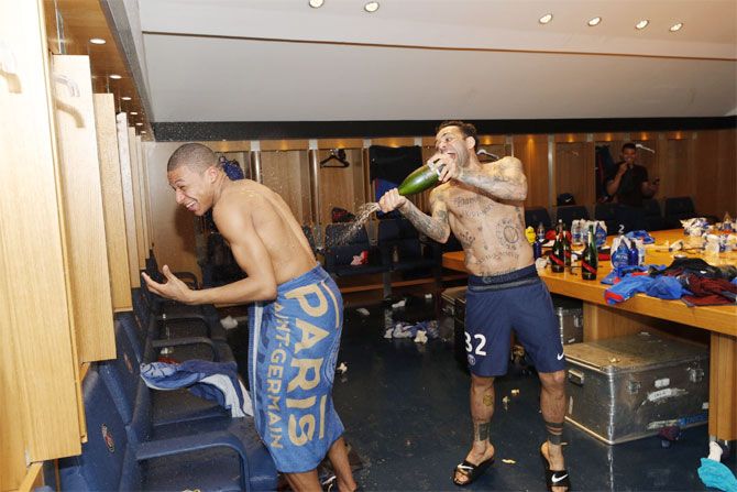 PSG's Kylian Mbappe and Dani Alves (right) celebrate in the dressing room after their title win