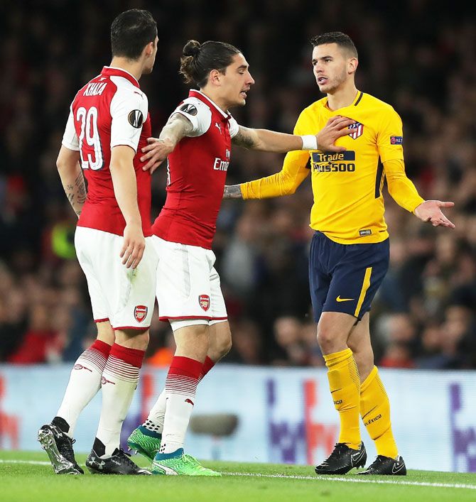 Arsenal's Granit Xhaka and Atletico Madrid's Lucas Hernandez are restrained as they clash