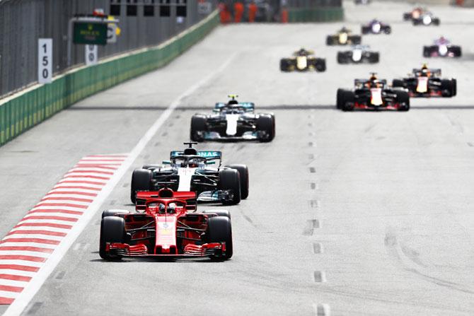 Germany's Sebastian Vettel driving the (5) Scuderia Ferrari SF71H leads Mercedes' British driver Lewis Hamilton driving the (44) Mercedes WO9 and the rest of the field during the Azerbaijan Formula One Grand Prix at Baku City Circuit in Baku, Azerbaijan, on Sunday