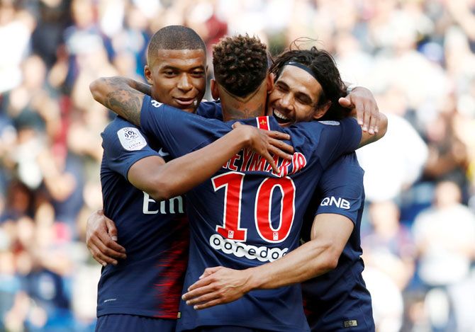 Paris St Germain's Edinson Cavani celebrates scoring their first goal with Neymar and Kylian Mbappe during their Ligue 1 match against Angers at the Parc des Princes in Paris on Saturday