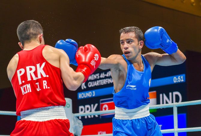 India's Amit Panghal (Blue) and PR Koreas Ryong Jong compete in the Men's Light Fly (46-49kg) Quarter-final boxing event in the 18th Asian Games 2018 in Jakarta, Indonesia on Wednesday