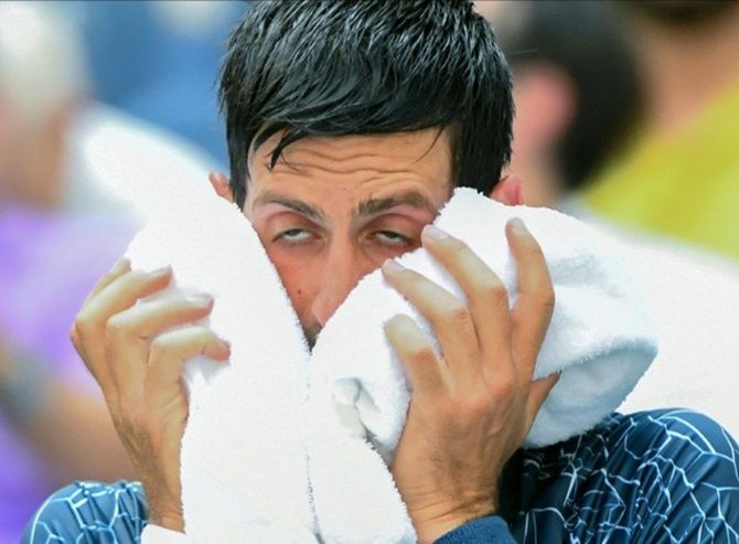 Serbia's Novak Djokovic copes with the extreme heat while playing Marton Fucsovics of Hungary in the first round on Tuesday
