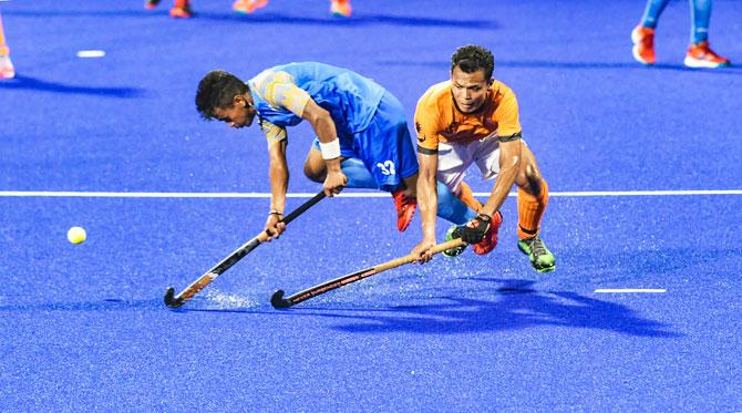 India's Vivek Prasad (left) and a Malaysian player in action during the men's hockey semi-final match at the 18th Asian Games 2018, in Jakarta, Indonesia on Thursday