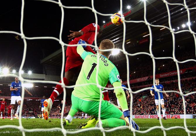 Divock Origi scores the winning goal for Liverpool past Everton goalkeeper Jordan Pickford