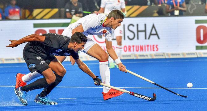 Spain's Xavi Lleonart (in white) and New Zealand's Arun Panchia vie for the ball, during their Men's Hockey World Cup matcj at Kalinga Stadium in Bhubaneswar on Thursday