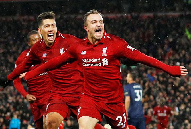 Liverpool's Xherdan Shaqiri celebrates with Roberto Firmino and Georginio Wijnaldum after scoring their third goal against Manchester United on Sunday 