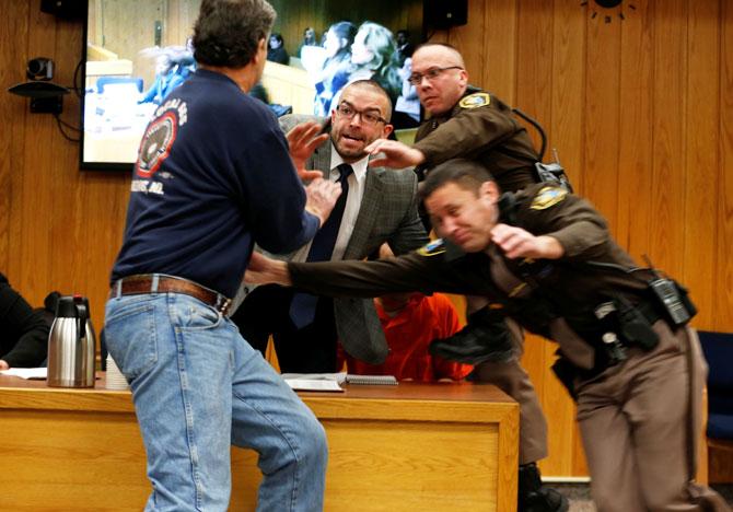 Randall Margraves (left) lunges at Larry Nassar, (wearing orange) a former team USA Gymnastics doctor who pleaded guilty in November 2017 to sexual assault charges, during victim statements of his sentencing in the Eaton County Circuit Court in Charlotte, Michigan, USA, on Friday