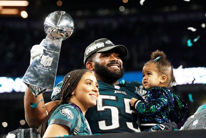 Philadelphia Eagles' Brandon Graham holds up the Vince Lombardi Trophy as he celebrates with his family after winning Super Bowl LII