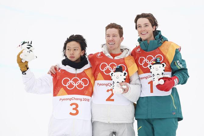 Silver medalist Ayumu Hirano of Japan, gold medalist Shaun White of the United States and bronze medalist Scotty James of Australia pose during the victory ceremony for the snowboard men's halfpipe final on Wednesday