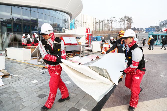 Firefighters remove the debris of a damaged food stall that was blown over by the wind at Gangneung Olympic Park in Gangneung, South Korea on Wednesday