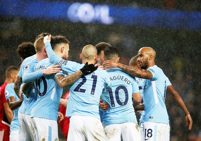Manchester City's Sergio Aguero celebrates with teammates after scoring their third goal against Watford at the Etihad Stadium in London on Tuesday