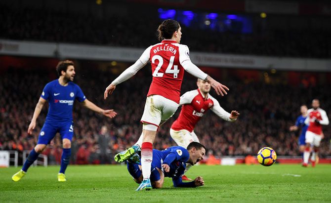Chelsea's Eden Hazard is fouled by Arsenal's Hector Bellerin leading to Chelsea being awarded a penalty by match referee Anthony Taylor