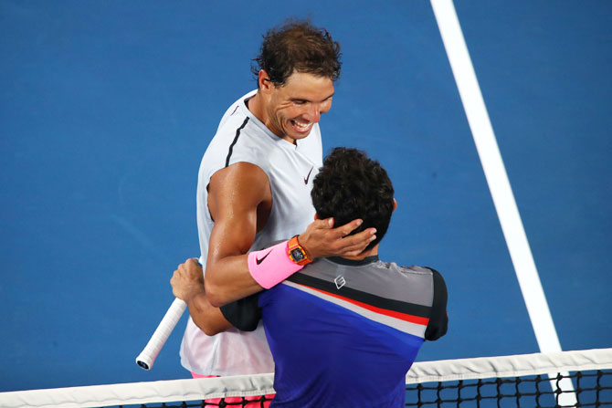 Rafael Nadal is congratulated by Victor Estrella Burgos at the net