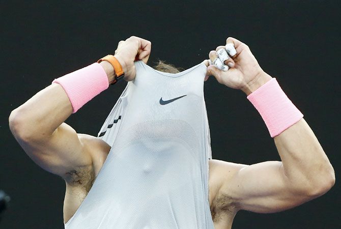 Spain's Rafael Nadal changes his shirt during his opening round match against Dominican Republic'S Victor Estrella Burgos at the Australian Open in Melbourne on Monday
