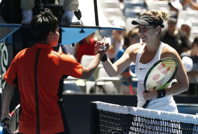 Thailand's Luksika Kumkhum is congratulated by Switzerland's Belinda Bencic