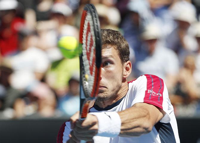 Spain's Pablo Carreno Busta plays a return against France's Gilles Simon