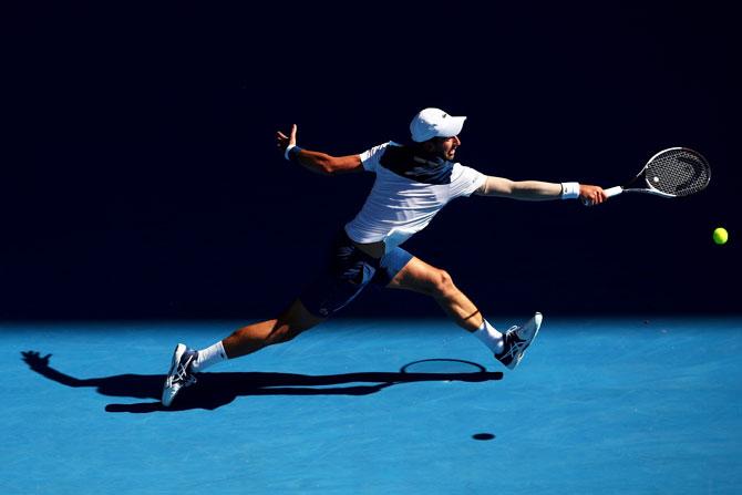 Serbia's Novak Djokovic stretches as he attempts a backhand return in his second round match against France's Gael Monfils